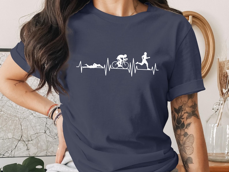 Navy t-shirt with white graphic of a heartbeat line with running and cycling figures.