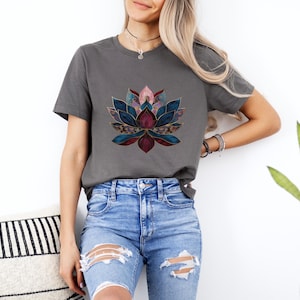 May include: A charcoal grey t-shirt with a colorful geometric lotus flower design. The lotus flower is made up of shades of blue, pink, and burgundy.