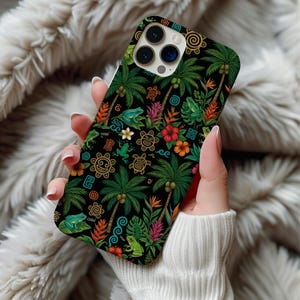 May include: A black phone case featuring a tropical design with palm trees, frogs, flowers, and tribal patterns in green, red, orange, and gold. The case has a glossy finish and is designed for a smartphone.
