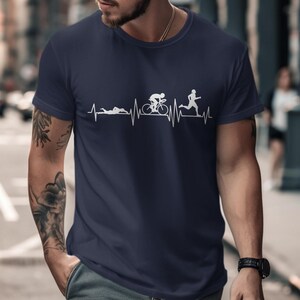 Dark blue t-shirt with a white graphic depicting triathlon activities on a heart rhythm line.