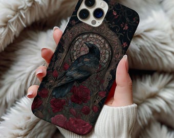 Può includere: Custodia per telefono con un corvo scuro davanti a un design a vetrata, circondato da rose rosse. Lo sfondo nero presenta dettagli floreali, creando un'estetica gotica.