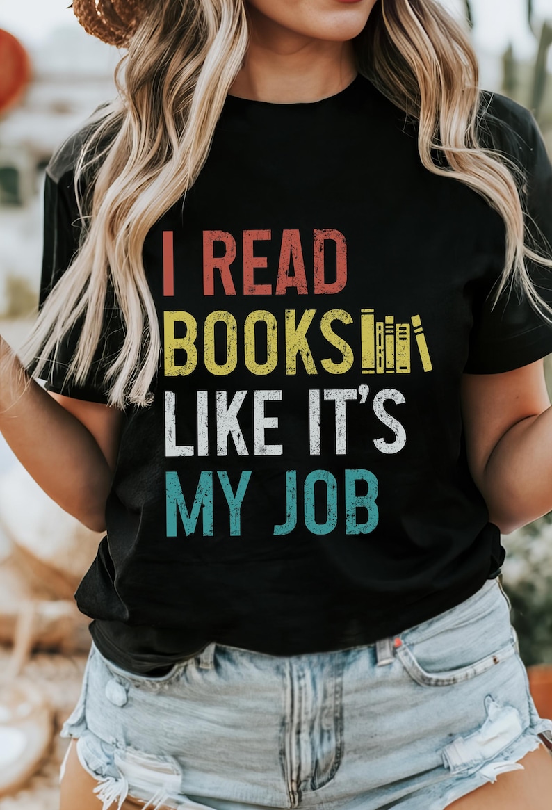 May include: Black t-shirt with a vintage-style graphic that reads "I read books like it's my job". The graphic features a stack of books in yellow and red.