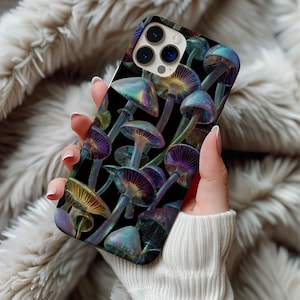 Puede incluir: Funda de teléfono con un vibrante patrón de hongos iridiscentes sobre un fondo negro. El diseño incluye varias formas de hongos en tonos morados, azules y amarillos. La funda está sujeta en una mano.
