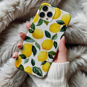 Może przedstawiać: Białe etui na telefon z akwarelowym wzorem żółtych cytryn i zielonych liści. Etui ma błyszczące wykończenie i wycięcie na aparat. Wzór powtarza się na tylnej stronie etui.
