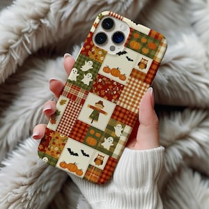 May include: A smartphone case featuring a patchwork design of autumn and Halloween motifs. The pattern includes orange pumpkins, white ghosts, brown owls, black bats, a scarecrow, and plaid squares in shades of red, orange, green, and cream.