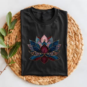 May include: Black t-shirt with a colorful lotus flower design. The flower is made up of different shades of blue, purple, pink, and red. The flower is outlined in gold.