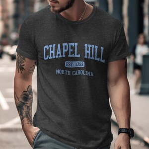 Dark grey t-shirt with "Chapel Hill Est. 1793 North Carolina" in blue text.