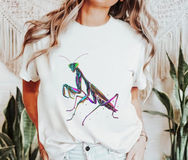 May include: White t-shirt with a colorful graphic of a praying mantis on the front.