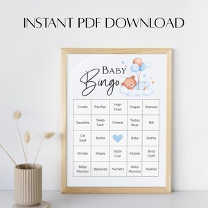 Puede incluir: Un juego de Baby Bingo enmarcado con un marco de madera clara. El tablero del juego presenta un oso de peluche, globos y estrellas. Las palabras "Baby Bingo" están en la parte superior, con una lista de artículos para bebés debajo. El texto "INSTANT PDF DOWNLOAD" está en la parte superior.