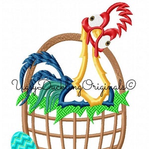 May include: An embroidered design of a yellow rooster with red wattles and a blue tail, peeking out of a brown wicker basket with green leaves. A blue and green Easter egg is beside the basket. The text "Ugly Duckling Originals ©" is below the basket.