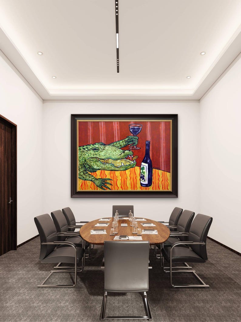 May include: A framed painting hanging on a wall above a conference table. The artwork depicts a green alligator holding a glass of red wine and eating a snack next to a blue wine bottle with a grape label, set against a red and orange background.