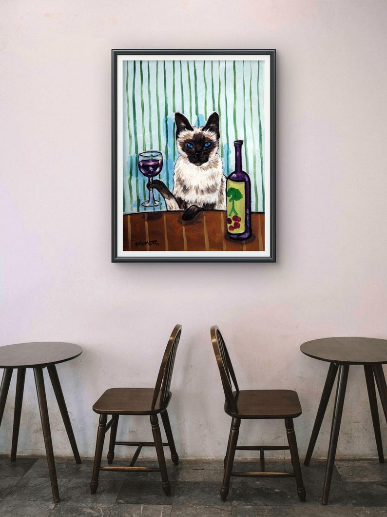以下が含まれることがあります： 青い目をしたシャム猫がテーブルに座っている額入り絵画。猫は片方の前足で赤ワインのグラスを持ち、その横には緑の木と赤い果実のグラフィックが描かれた紫色のボトルが置かれている。背景は垂直の緑色のストライプ模様。