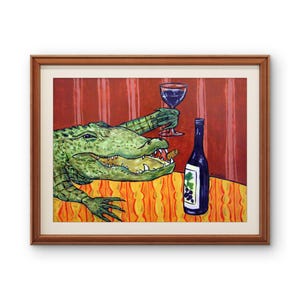 May include: A framed painting depicting a green alligator with an open mouth holding a wine glass in one claw. A dark blue wine bottle with a grape label sits on a yellow and orange striped table against a red striped background.