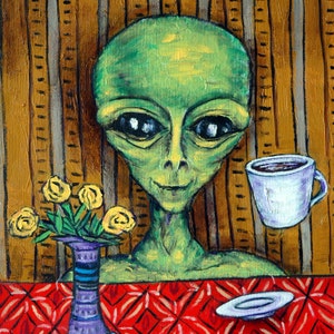 May include: A green alien with large eyes and a wide smile sits at a table with a cup of coffee and a plate. A bouquet of yellow flowers sits in a blue vase on the table. The background is a wooden wall with vertical lines.