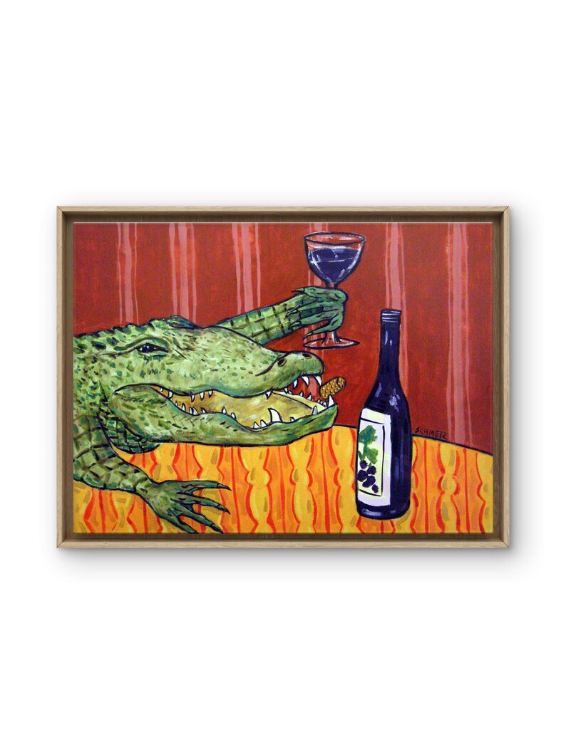 May include: A framed painting depicts a green alligator with an open mouth holding a wine glass in one claw. A dark wine bottle with a grape label sits on an orange and yellow patterned tablecloth. The background features red vertical stripes.