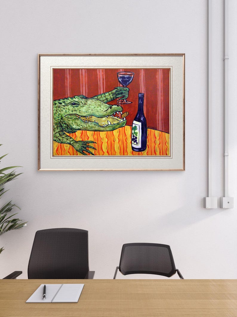 May include: A framed painting depicting a green alligator with an open mouth holding a glass of red wine. Next to the alligator is a dark blue wine bottle with a grape label. The scene is set against a red striped wall and an orange patterned table.