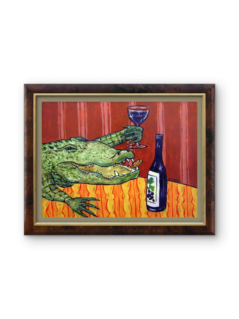 May include: A framed painting featuring a green alligator with an open mouth holding a glass of red wine. Next to the alligator is a dark blue wine bottle with a grape label. The scene is set against a red striped wall and an orange tablecloth.