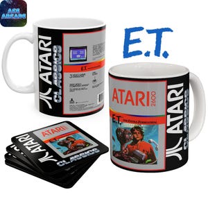 May include: Two white ceramic mugs and a stack of square coasters featuring Atari 2600 E.T. The Extra-Terrestrial game box art. The mugs display the Atari Classics logo, game information, and the iconic movie scene with E.T. and a boy in a red hoodie.