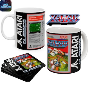 Puede incluir: Dos tazas de cerámica blanca y una pila de posavasos cuadrados con la marca Atari Classics y el arte del videojuego Xevious. Las tazas muestran el diseño de la caja del juego, el título y texto descriptivo, al igual que los posavasos.