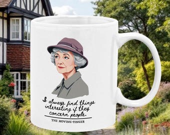 Op de afbeelding: Een witte keramische mok met een cartoonillustratie van Agatha Christie, auteur van The Moving Finger, en een citaat uit het boek: "Ik vind dingen altijd interessant als ze mensen betreffen."