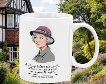 Op de afbeelding: Een witte keramische mok met een zwart-witte illustratie van een vrouw met een paarse hoed en een citaat uit het boek "A Pocket Full of Rye" van Agatha Christie. Het citaat luidt: "Ik geloof altijd het ergste... Wat zo triest is, is dat je meestal gelijk hebt."