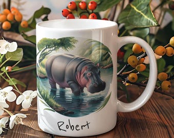May include: White ceramic mug with a colorful illustration of a hippopotamus in a pond. The mug has the name "Robert" written on the bottom.