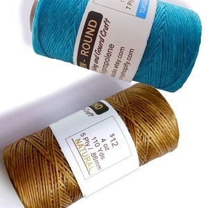 May include: Two spools of cord, one turquoise and one natural brown. The turquoise cord is labeled "EN-ROUND" and "7 Ply/1.86mm". The brown cord is labeled "ND" and "5 Ply/.86mm". Both spools are labeled with the price "$12" and the weight "4 oz".