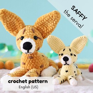 May include: Two crocheted serval cat toys, one large and one small, in shades of tan and cream with black spots. The larger cat has a white muzzle and the text "SAFFY the serval". The smaller cat has black spots and the text "crochet pattern English (US)".