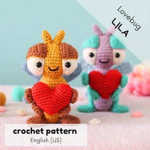 May include: Crochet pattern for a Lila Lovebug amigurumi toy. The pattern is written in English (US). The toy is a purple and green crocheted bug holding a red heart. The pattern is available for download.