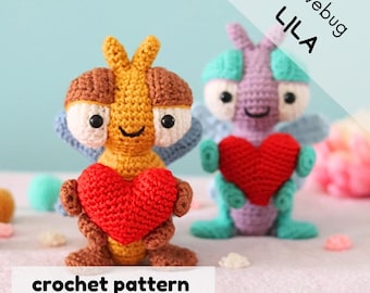 May include: Crochet pattern for a Lila Lovebug amigurumi toy. The pattern is written in English (US). The toy is a purple and green crocheted bug holding a red heart. The pattern is available for download.