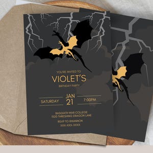Könnte beinhalten: Eine schwarze und goldene Geburtstagseinladung mit einer Silhouette von zwei Drachen, die durch einen stürmischen Himmel fliegen. Die Einladung lautet "Sie sind eingeladen zu Violets Geburtstagsparty" mit Datum und Uhrzeit der Party. Der Ort ist angegeben als "Basgiath War College, 1320 Threshing Dragon Lane".