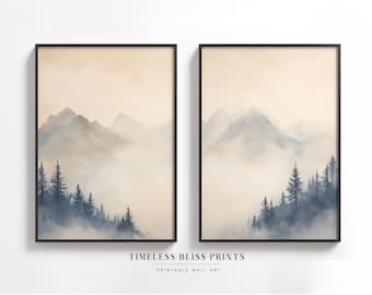 Puede incluir: Dos impresiones enmarcadas de una pintura de acuarela de un paisaje montañoso brumoso con un bosque de árboles en primer plano. Las impresiones están en marcos negros y tienen un fondo beige claro.