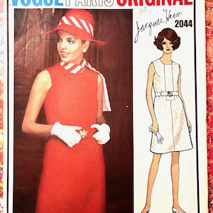 May include: Vintage Vogue Paris Original sewing pattern featuring a woman in a red dress and hat. The pattern includes a line drawing of a sleeveless dress with a belt. The text "Jacques Heim 2044" is visible.
