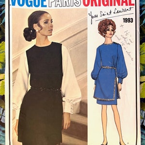 Könnte beinhalten: Ein Vintage-Schnittmuster von Vogue Paris Original mit Designs von Yves Saint Laurent aus dem Jahr 1993. Das Schnittmuster zeigt ein schwarz-weißes Kleid und ein blaues Kleid mit langen Ärmeln. Der Text auf dem Muster lautet "Vogue Paris Original" und "Yves Saint Laurent 1993."