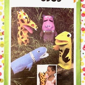 May include: Simplicity 8365 sewing pattern featuring animal hand puppets. The pattern includes instructions for a giraffe, hippo, shark, and frog puppet. The puppets are made of felt and have detailed features. The pattern is one size.