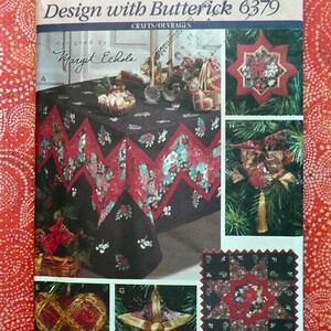 May include: Butterick pattern for crafts, featuring a tablecloth with a floral design and other holiday-themed decorations. The pattern includes a star-shaped ornament and a heart-shaped ornament. The text "Butterick Design with Butterick 6379" is visible.