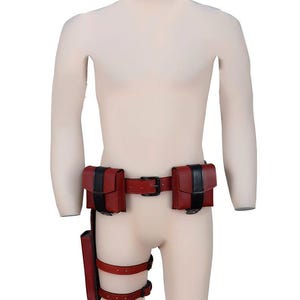 May include: A red and black leather belt with two pouches on each side and a thigh holster. The belt has a black buckle and the pouches have black trim.