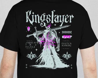 May include: Black t-shirt featuring a skeletal figure with a sword, the word "Kingslayer" above the graphic, and additional text and design elements. The design incorporates shades of white, pink, and purple.