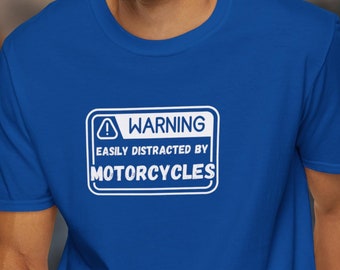 May include: A royal blue t-shirt with a white warning sign that reads "WARNING EASILY DISTRACTED BY MOTORCYCLES".
