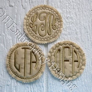 Puede incluir: Tres posavasos redondos de tela con iniciales de monograma bordadas en oro. Los posavasos tienen un borde festoneado.