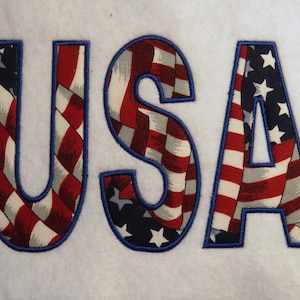 May include: USA spelled out in large blue outlined letters, each letter filled with a red, white, and blue American flag pattern.