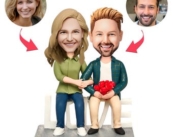 May include: A figurine of a couple seated on a bench, holding hands and a bouquet of red roses. The woman wears a green shirt and blue jeans. The man wears a teal plaid jacket and tan trousers. Portraits of a woman and a man are in the background.