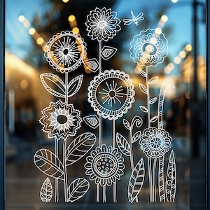 Könnte beinhalten: Weiße Umrisszeichnung von Blumen auf einem Glasfenster. Die Blumen sind stilisiert und haben komplizierte Details. Der Hintergrund ist verschwommen und unscharf.