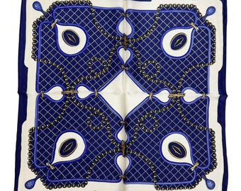 May include: A white silk scarf with a blue and gold chain pattern. The pattern features a repeating design of interlocking chains and ovals.