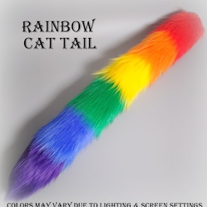 May include: A long, plush cat tail made of faux fur featuring a vibrant rainbow gradient pattern. The text RAINBOW CAT TAIL is printed in black at the top, and the text COLORS MAY VARY DUE TO LIGHTING & SCREEN SETTINGS is at the bottom.