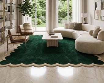 May include: A rectangular area rug featuring a deep forest green center with a thick, textured cream-colored scalloped border. The rug has a plush, high-pile surface and is positioned on a light-colored marble floor in a living room setting.