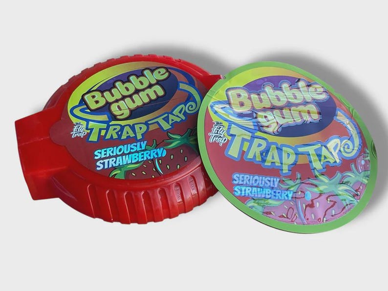 May include: Two containers of bubble gum. One is red and the other is green. Both have the words "Bubble Gum Trap Tape" and "Seriously Strawberry" printed on them. The bubble gum containers are round.