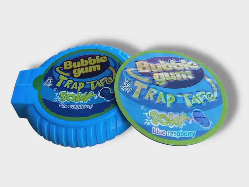 May include: Two blue bubble gum containers. One is a dispenser, the other a lid. Both have the text "Bubble Gum Trap Tape Sour Blue Raspberry" in a colorful design. The dispenser is a bright blue color.