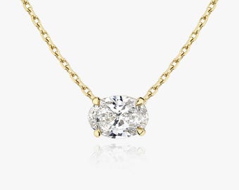 May include: A delicate gold chain necklace with a single oval-shaped diamond pendant.