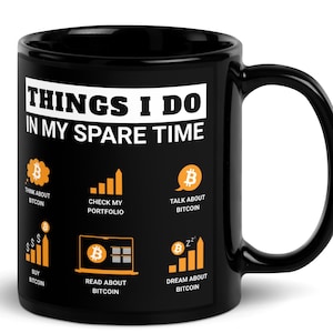 Könnte beinhalten: Schwarze Kaffeetasse mit einem weißen Design, auf dem "Things I do in my spare time" steht und Symbole im Zusammenhang mit Bitcoin abgebildet sind. Die Symbole umfassen ein Bitcoin-Symbol, ein Diagramm, einen Laptop und eine Traumwolke.